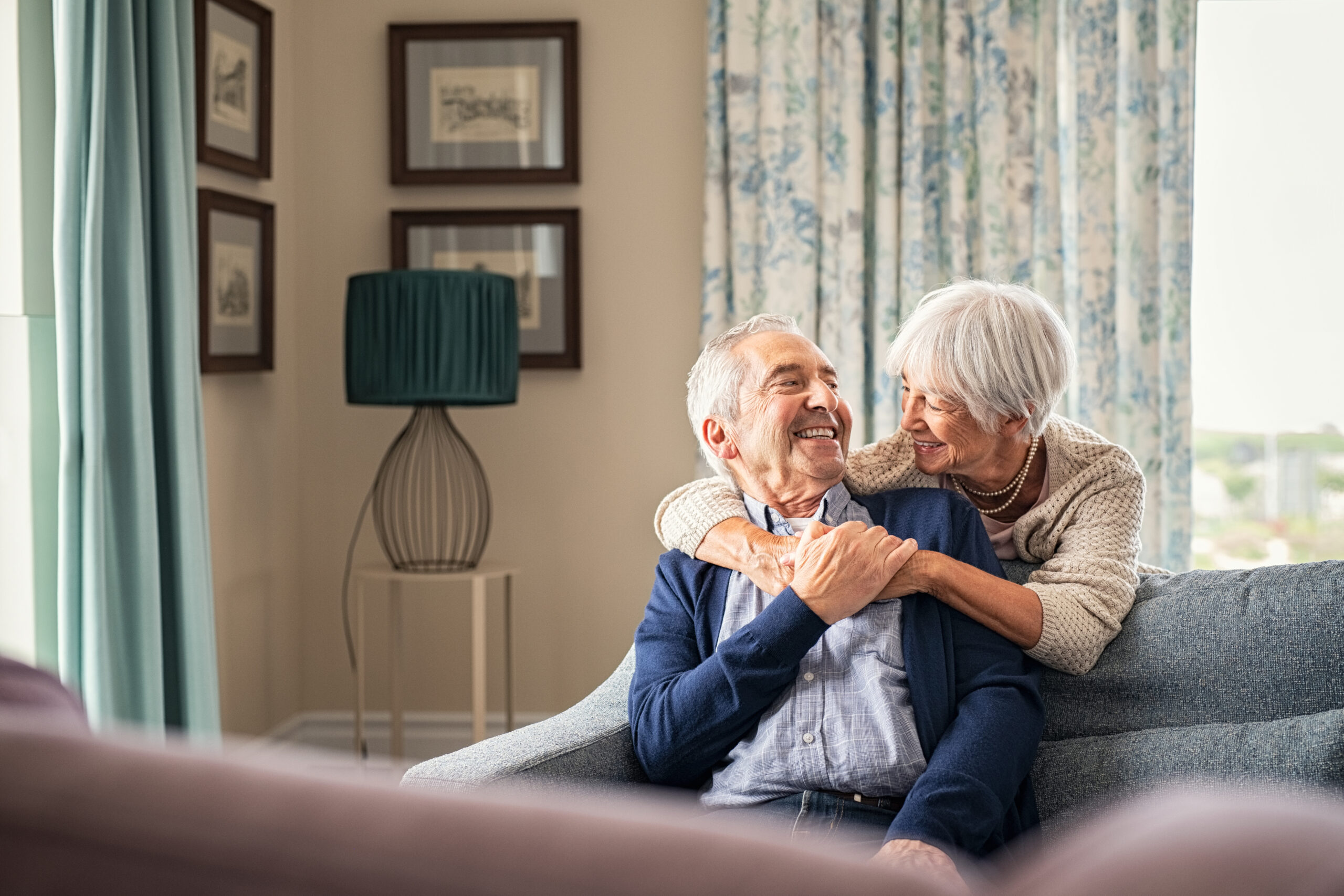 Senior couple smiling and enjoying each other's company together in their house.